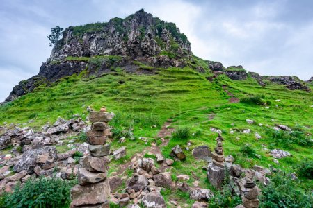 Foto de Castillo como prominencia de basalto rocoso, con hermosas vistas de los alrededores, colinas y montículos en forma de cono, un paisaje cubierto de hierba lindo, surrealista, fantasía like.. - Imagen libre de derechos