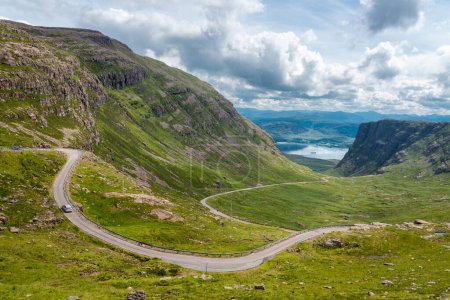 Der Pass der Rinder, eine kurvenreiche einspurige Straße durch die Berge der Applecross-Halbinsel, in Wester Ross, Schottische Highlands.Hohe Klippen wie Berge, felsige Landschaft, im Sommer.