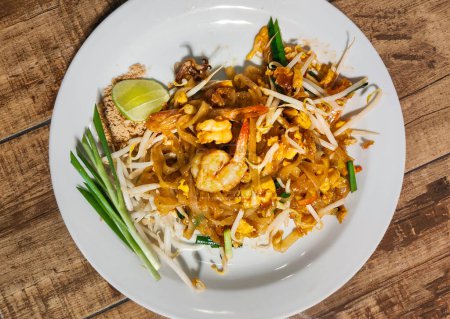 Photo for Served at a street food restaurant,ready to eat. Most popular Thai dish with western tourists.Delicious,tasty food with peanuts,shrimp,beansprout,noodles,spring onion and a slice of lime. - Royalty Free Image