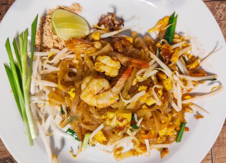 Photo for Served at a street food restaurant,ready to eat. Most popular Thai dish with western tourists.Delicious,tasty food with peanuts,shrimp,beansprout,noodles,spring onion and a slice of lime. - Royalty Free Image