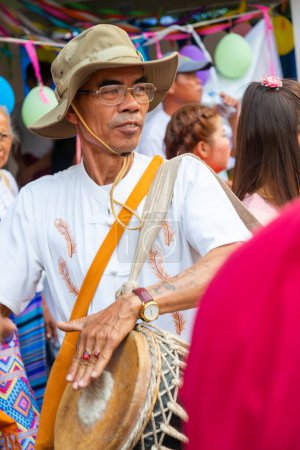 Téléchargez les photos : Pai, Thaïlande du Nord-4 avril 2023 : Un des nombreux percussionnistes et musiciens de la foule passante, lors de la célébration bouddhiste colorée, où les garçons sont ordonnés moines, dans le nord de la Thaïlande. - en image libre de droit
