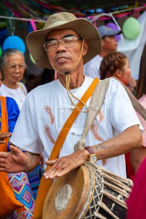 Téléchargez les photos : Pai, Thaïlande du Nord-4 avril 2023 : Un des nombreux percussionnistes et musiciens de la foule passante, lors de la célébration bouddhiste colorée, où les garçons sont ordonnés moines, dans le nord de la Thaïlande. - en image libre de droit