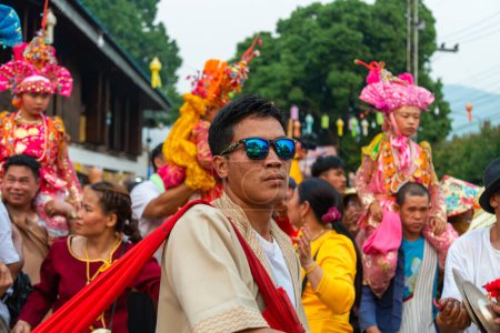 Téléchargez les photos : Pai, Nord de la Thaïlande-4 avril 2023 : Super énergique après les festivités Covid abondent dans la foule qui passe, au festival bouddhiste coloré, où les garçons sont ordonnés moines. - en image libre de droit
