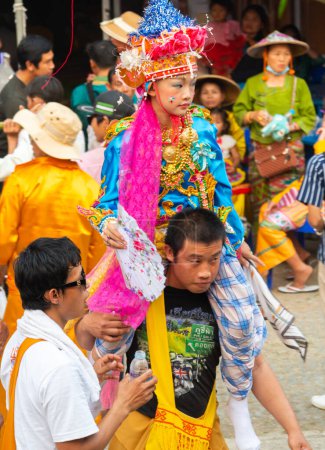 Photo for Pai,Mae Hong Son,Thailand-April 4th 2023:Boys,aged between seven and fourteen years,about to be ordained as Buddhist monks,are carried on men's shoulders through the streets,as the crowds celebrate. - Royalty Free Image