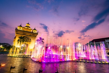 Beautiful,colorful light and fountain water display,synchronized with patriotic Lao music from nearby speakers,the Patuxay War memorial illuminated in the background.Performed every day,at dusk.