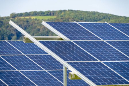 Téléchargez les photos : Gros plan de cellules solaires, en rangées de panneaux, sur un site à la campagne, pendant l'été en Angleterre rurale, fournissant une énergie propre et durable aux zones et villages locaux, dans les Midlands britanniques. - en image libre de droit