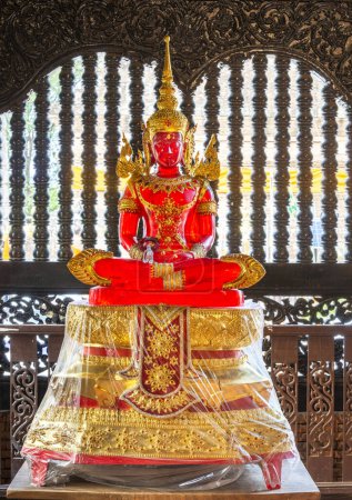 Photo for Sunlight shining through transparent Buddha image,in the Temple interior,beautiful,vibrant,ornate red and gold colored,standing before a nearby window. - Royalty Free Image