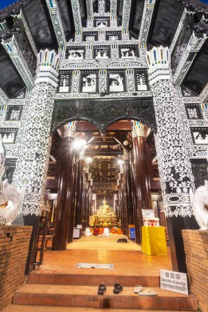 Photo for Illuminated by lights inside and out of the ancient structure,monks chant and pray inside,shoes left on doorway steps,exquisite,intricate white decorations and carvings adorn facade and roof above. - Royalty Free Image