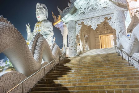 Illuminated at dusk,architecture is splendid with the mix of Chinese Guan Yin Statue, dragon stairs, white marble Buddha and Thaj style architecture.Beautiful modern Thai temple.