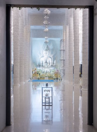 Modern Thai interior design.Beautifully illuminated shiny marble and glass chandeliers hanging from ceiling,a mix of Chinese Guan Yin and Thaj style architecture.
