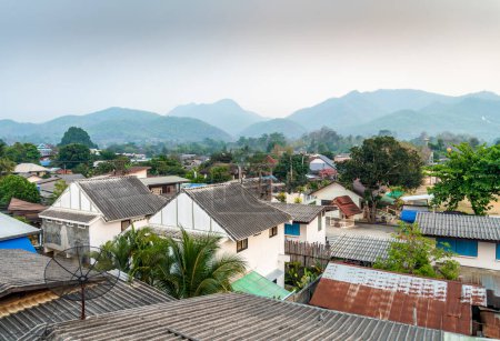 As dusk approaches,a beautiful,scenic,peaceful,yet expanding town,many small buildings,near the Myanmar border,surrounded by mountains,a haven for travelers,hippies and Thai tourists from Chiangmai.
