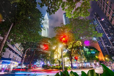 Téléchargez les photos : Kuala Lumpur, Malaisie-15 avril 2023 : Dans la capitale malaisienne, les lumières vives et colorées et le trafic achalandé continuent du crépuscule à l'aube, les nuages au-dessus rayonnant de la lumière intense ci-dessous. - en image libre de droit