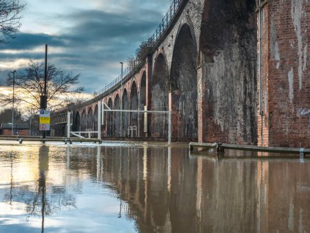Extreme weather conditions,cause extensive flooding,the Victorian rail viaduct overhead in previously dry areas,roads cut off,flooded fields and highways,trees submerged in river water all around.