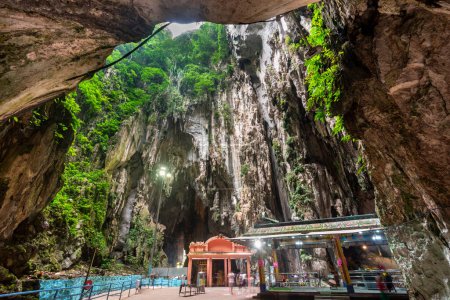 Des structures religieuses hindoues, construites en 1920, ornent les espaces intérieurs de la vaste grotte sacrée de calcaire, avec une ouverture sur le ciel à une extrémité, un site culturel emblématique et une destination touristique malaisienne.
