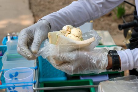 Selektiver Fokus weißes Kokosmilch-Eis in billigem Brot in den Händen eines Eisverkäufers, der im Sommer am Straßenrand vorbeifährt, um zu verkaufen