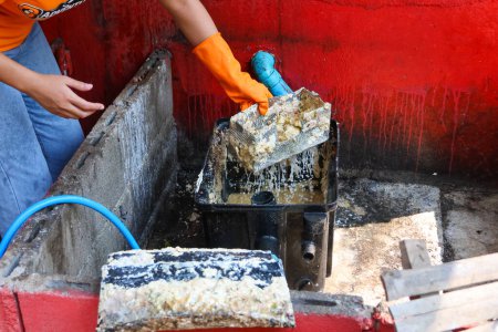 Photo for Grease traps from dirty debris being cleaned with a scoop are discarded. How to treat water with a grease trap. - Royalty Free Image