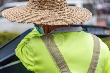 Foto de Trabajador con un sombrero verde y guantes - Imagen libre de derechos