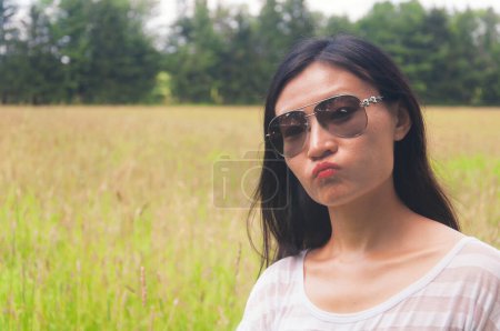 Téléchargez les photos : A happy chinese woman standing in a meadow at topsmead state forest park in litchfield connecticut. - en image libre de droit