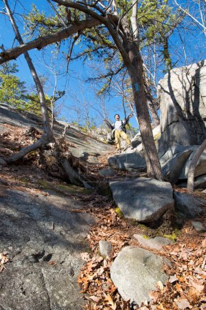 Téléchargez les photos : Une Chinoise randonnant sur les falaises de pierre blanche remonte une pente rocheuse dans le connecticut de plymouth par une journée ensoleillée de ciel bleu. - en image libre de droit