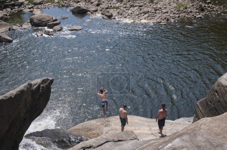 Foto de Canaan, Connecticut. 28 de julio de 2019. Un hombre saltando de las rocas al agua en Great Falls en Falls Village Canaan Connecticut en un soleado día de verano. - Imagen libre de derechos