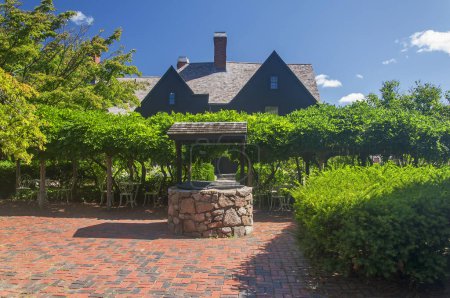 Un pozo de piedra en la casa de las siete caballerizas en Salem Massachusetts en un día soleado.