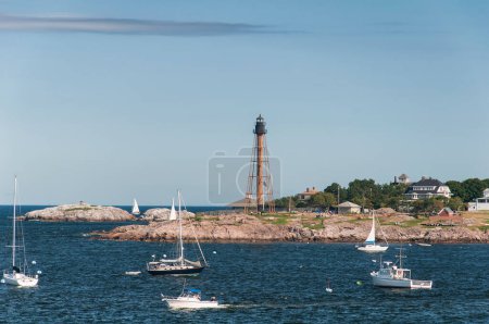 Boats moored offshore near Marblehead Lighthouse in marblehead Massachusetts. 