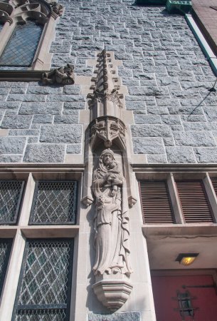 A religious statue of the virgin mary holding baby jesus on the exterior of a church in Mount Vernon area of Baltimore Maryland.