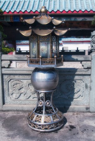 A metal urn at the Chi Wan Tian Hou Temple in Shenzhen China on a sunny day.