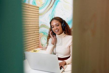 Photo for Shot of young office worker sitting in private booth, on remote call headset. High quality photo - Royalty Free Image