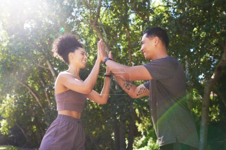 Photo for Beautiful fit couple give each other double high five after trail run outdoors. High quality photo - Royalty Free Image