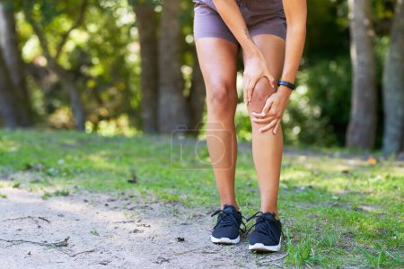 Photo for Close up of woman holding knee in pain, sports injury inflammation trail run. High quality photo - Royalty Free Image