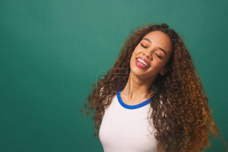 Young biracial woman dancing flipping hair, green studio background. High quality illustration