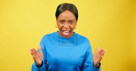 Téléchargez les photos : Femme en colère gronde et crie, criant avec des gestes de main, studio jaune. Photo de haute qualité - en image libre de droit