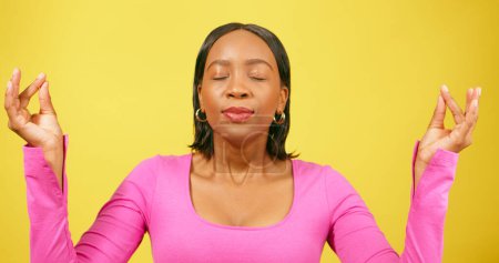 Téléchargez les photos : Belle femme noire respire et médite, se sentant relaxer heureux, studio jaune. Photo de haute qualité - en image libre de droit