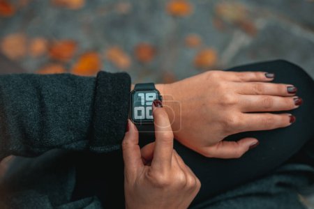 Photo for Business, technology and people concept - close up of woman hands setting smart watch at park Time on the clock 19-00.Close up view with blurred background. Full frame. - Royalty Free Image