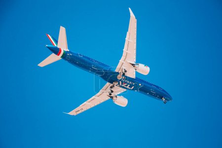 Photo for Low flying blue plane with white wings Airplane landing. Airplane on a blue isolated background. High quality photo - Royalty Free Image
