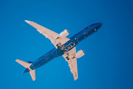 Foto de Italia, Lombardía, Milán 1.12.2023. Avión contra el cielo azul. El avión aterriza en el aeropuerto italiano Linate. Foto de alta calidad - Imagen libre de derechos
