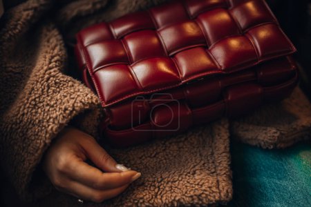 Foto de Milán, Italia - 17 de diciembre de 2023 Mujer viste de cuero rojo mini Bottega Veneta Cassette bag, street style details. Mujer en tren en la Estación Central de Milán. - Imagen libre de derechos