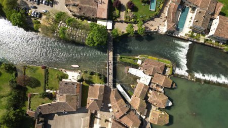 Beautiful panoramic aerial view of the mill village of Borghetto sul Mincio in the south of Lake Garda, in Veneto, Italy. Drone footage of the small medieval village. High quality aerial photo