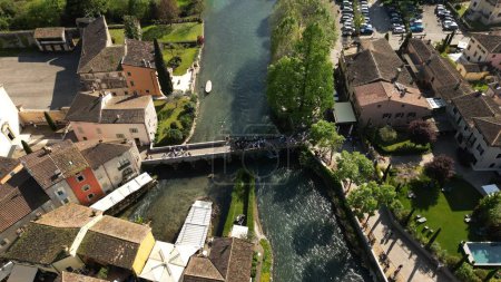Aerial view of the village of Borghetto sul Mincio in the south of Lake Garda, in Veneto, Italy. Drone footage of the small medieval village.