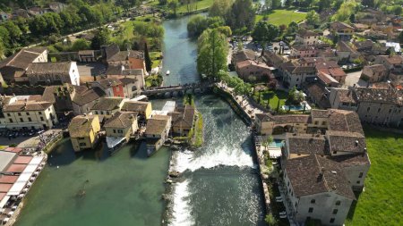 BBeautiful view of the village from above. Village of Borghetto sul Mincio in the south of Lake Garda, in Veneto, Italy. Drone footage of the small medieval village. 