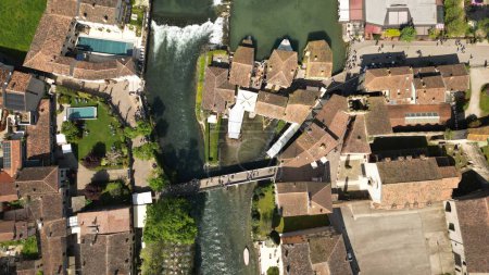 Aerial view of the cascade on the Mincio river, a picturesque place in Italy. Village of Borghetto sul Mincio in the south of Lake Garda, in Veneto, Italy. Drone footage of the small medieval village