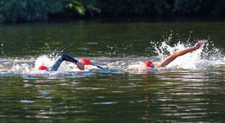 Téléchargez les photos : Triathlon swimmers swimming in river - en image libre de droit