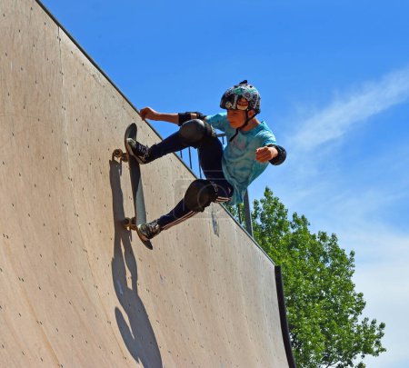 Photo for ST NEOTS, CAMBRIDGESHIRE, ENGLAND - JULY 03, 2022: Skateboarder performing stunt on Vert Ramp. - Royalty Free Image