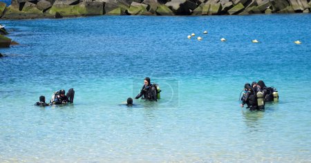 Photo for PLAYA BLANCA, LANZAROTE, SPAIN - MARCH 21, 2022: Group of people having a scuba diving lesson. - Royalty Free Image