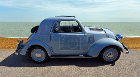 Photo for FELIXSTOWE, SUFFOLK, ENGLAND - MAY 06, 2018: Classic Fiat 500 parked on seafront promenade beach and sea in background. - Royalty Free Image