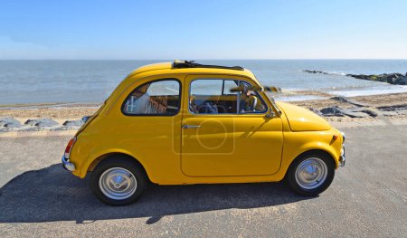 Photo for FELIXSTOWE, SUFFOLK, ENGLAND -  MAY 06, 2018: Classic  Yellow Fiat 500 parked on seafront promenade. - Royalty Free Image