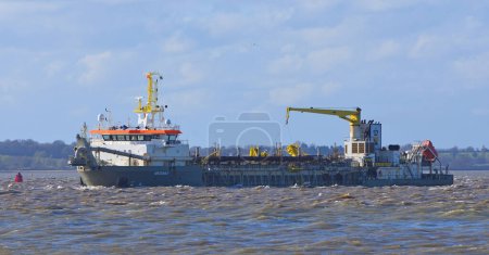 Photo for FELIXSTOWE, SUFFOLK, ENGLAND - MARCH 29, 2024:  Dredger in the estuary of the river Orwell at Felixstowe. - Royalty Free Image
