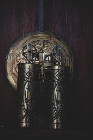 Photo for Old wooden clock with a pendulum hanging on the wall - Royalty Free Image