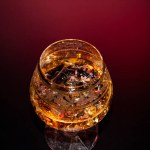 Glass with cognac and ice on a dark background. the concept of alcoholism and drinking